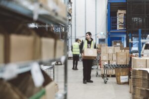 later cut off times blog- a person in a high vis holding a box ready to be stacked